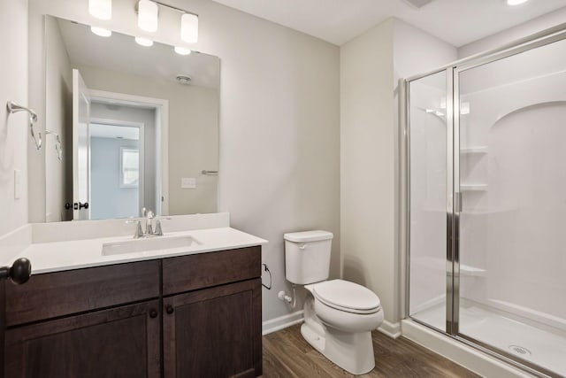 bathroom featuring walk in shower, toilet, vanity, and hardwood / wood-style flooring