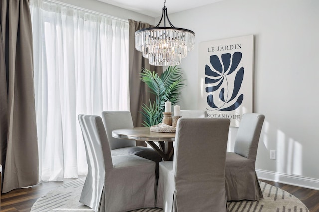 dining room with dark hardwood / wood-style floors and a chandelier