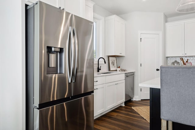 kitchen with white cabinets, appliances with stainless steel finishes, tasteful backsplash, and sink