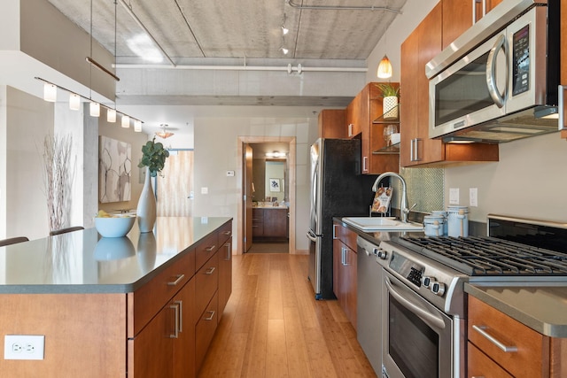 kitchen featuring appliances with stainless steel finishes, light hardwood / wood-style floors, and sink