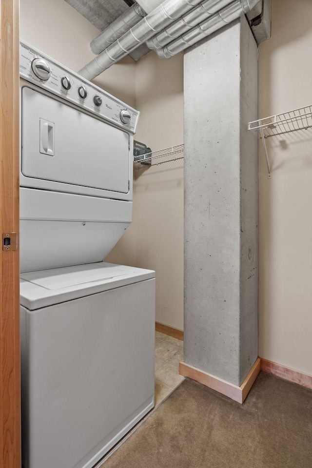 laundry room with carpet floors and stacked washer and dryer