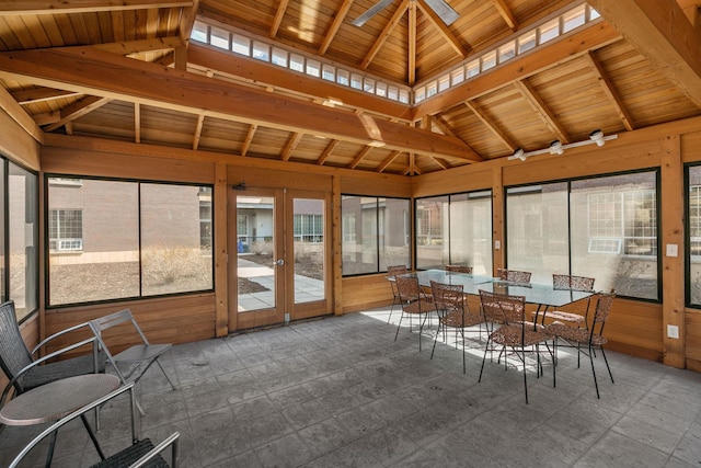 unfurnished sunroom featuring wooden ceiling, a healthy amount of sunlight, lofted ceiling with beams, and ceiling fan