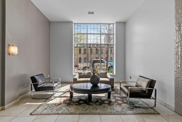 living area featuring a wall of windows and light tile patterned floors