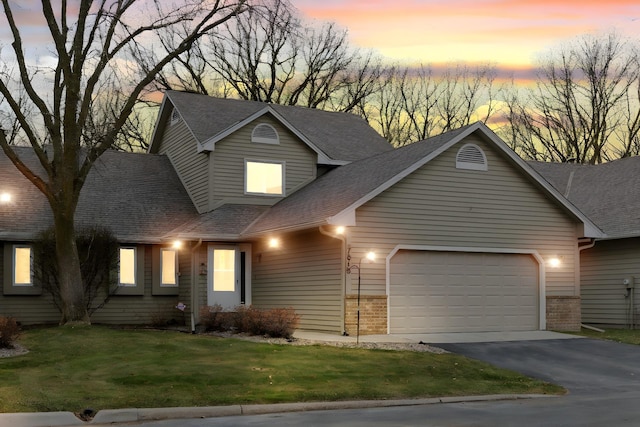 view of front of home featuring a lawn and a garage