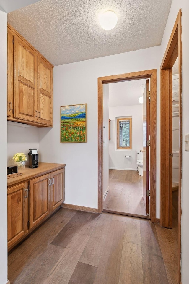 corridor featuring a textured ceiling and hardwood / wood-style flooring