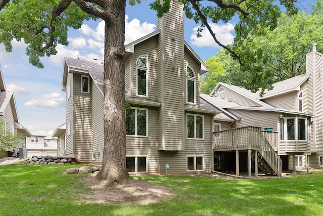 rear view of property featuring stairway, a lawn, a chimney, and a wooden deck