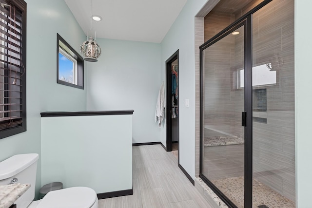 bathroom featuring recessed lighting, baseboards, a stall shower, and toilet