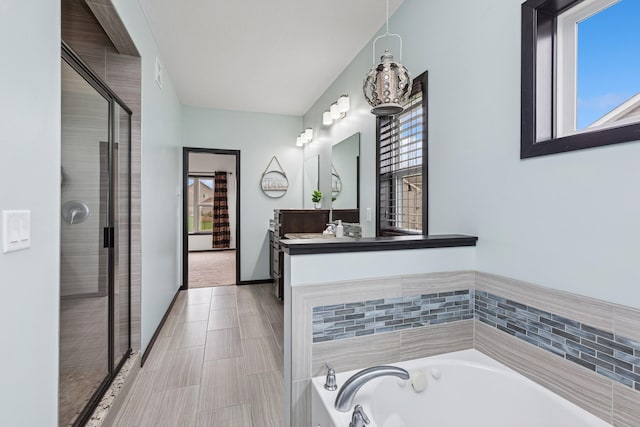 full bath with a garden tub, vanity, and a shower stall
