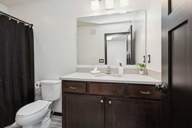 bathroom with vanity, toilet, and visible vents