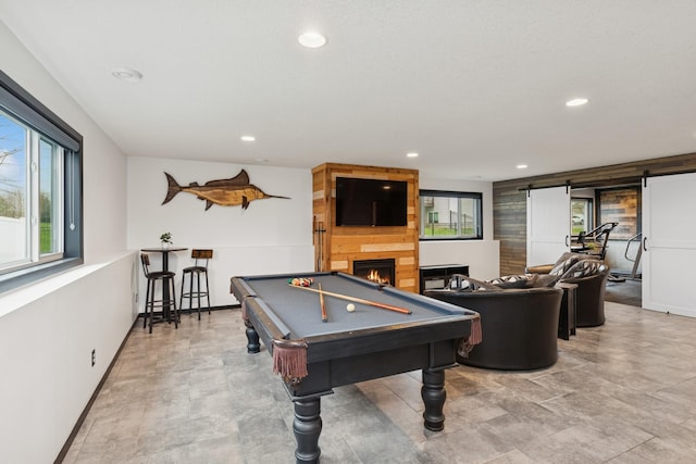recreation room featuring recessed lighting, baseboards, and a large fireplace