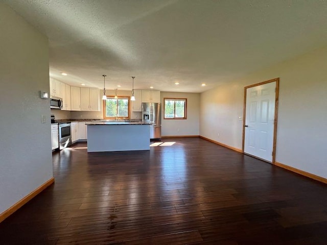 unfurnished living room with a textured ceiling and dark hardwood / wood-style floors