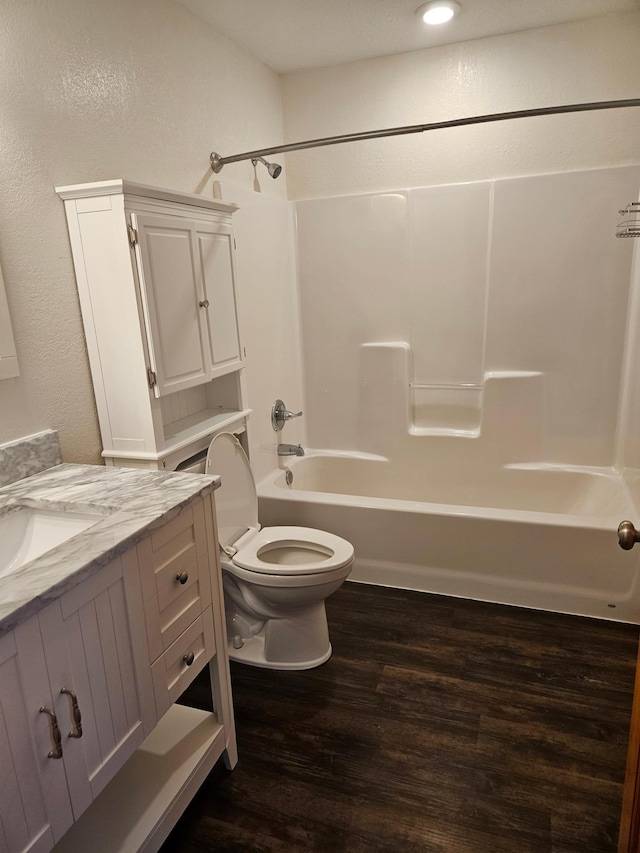 full bathroom with vanity, toilet, hardwood / wood-style floors, and shower / bathtub combination