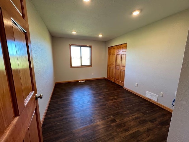 unfurnished bedroom with dark hardwood / wood-style floors