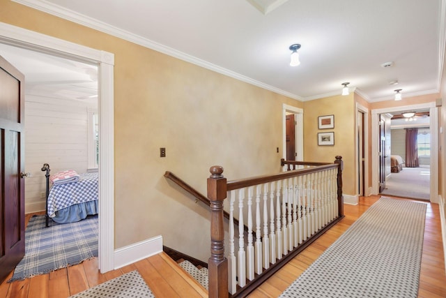 hallway featuring ornamental molding and light wood-type flooring