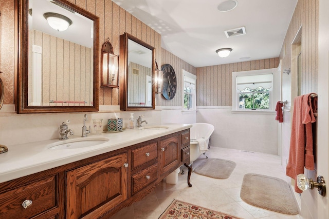 bathroom featuring tile patterned floors, vanity, and a bathing tub