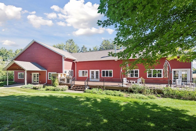 rear view of property featuring a wooden deck, a yard, and french doors