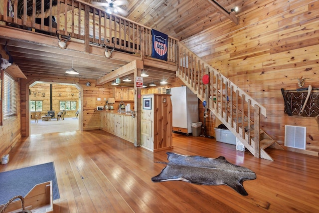 living room with wooden walls, wooden ceiling, and a wood stove