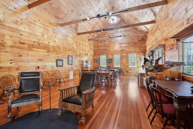 interior space featuring wooden walls, beamed ceiling, rail lighting, hardwood / wood-style flooring, and wood ceiling