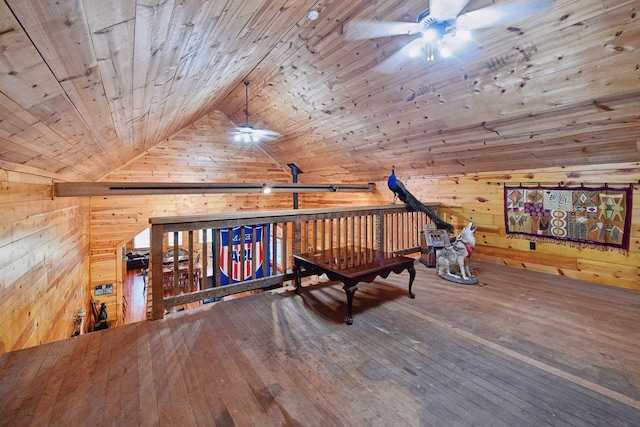 living area with hardwood / wood-style flooring, ceiling fan, wood ceiling, and wooden walls