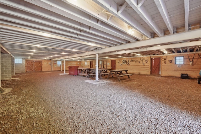 basement featuring wood walls