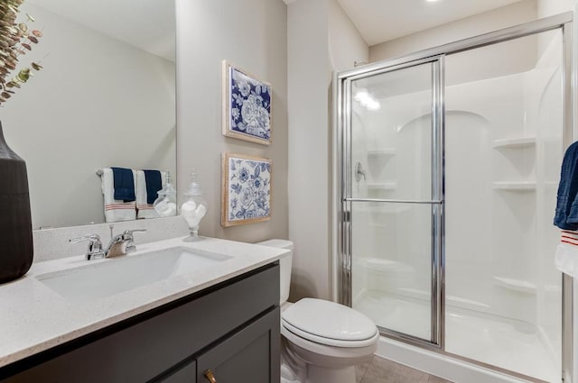 bathroom featuring walk in shower, vanity, tile patterned flooring, and toilet