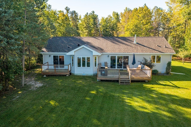 rear view of house featuring a deck and a yard