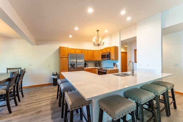 kitchen featuring hanging light fixtures, kitchen peninsula, stainless steel appliances, lofted ceiling, and sink