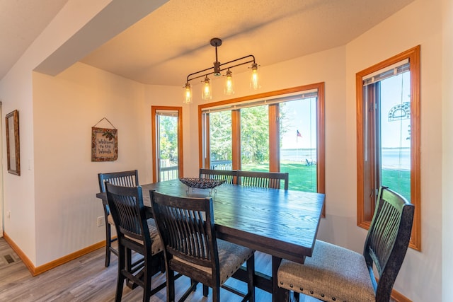 dining area with wood-type flooring and a textured ceiling