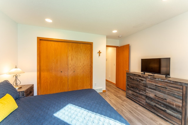 bedroom with a closet and light hardwood / wood-style flooring