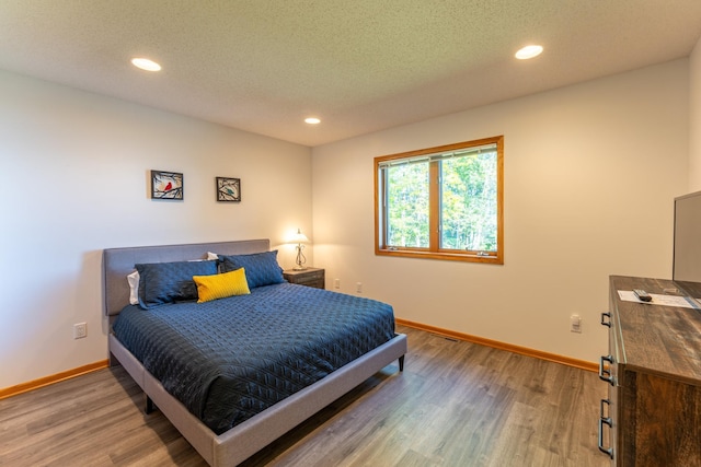 bedroom featuring a textured ceiling and hardwood / wood-style floors