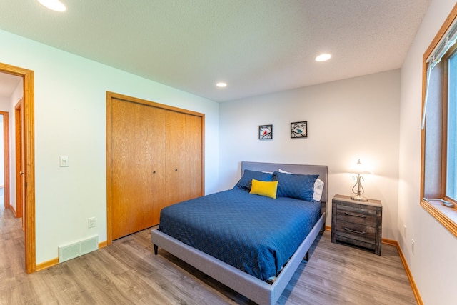 bedroom with wood-type flooring and a closet