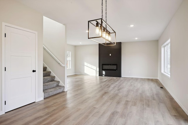 unfurnished living room featuring a large fireplace and light wood-type flooring