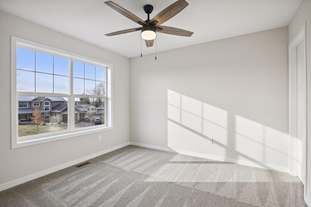 carpeted spare room featuring ceiling fan