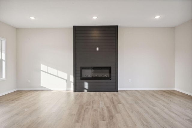 unfurnished living room featuring light hardwood / wood-style floors and a fireplace