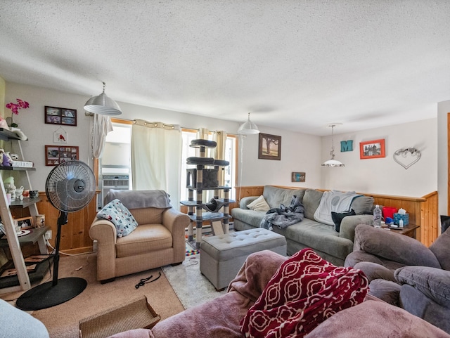 carpeted living room featuring cooling unit, wood walls, and a textured ceiling