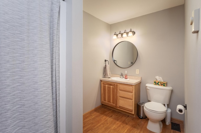 bathroom featuring vanity, hardwood / wood-style floors, and toilet