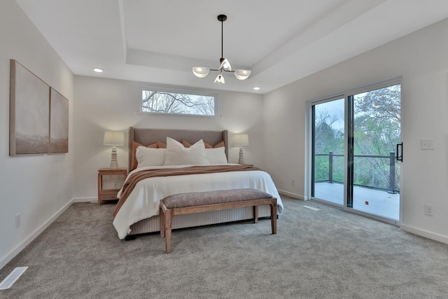 bedroom featuring a chandelier, access to exterior, light colored carpet, and a tray ceiling