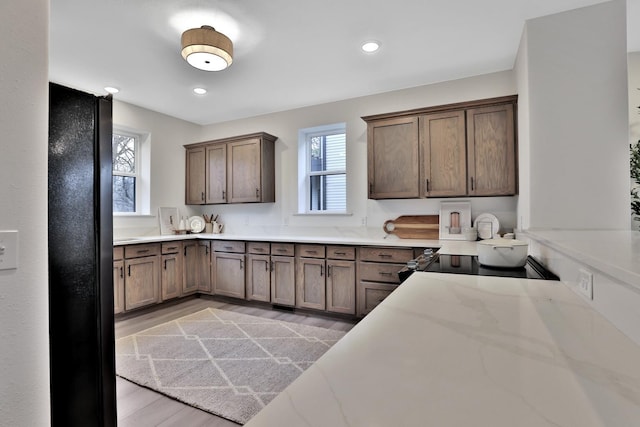 kitchen with black fridge, light hardwood / wood-style flooring, and stove