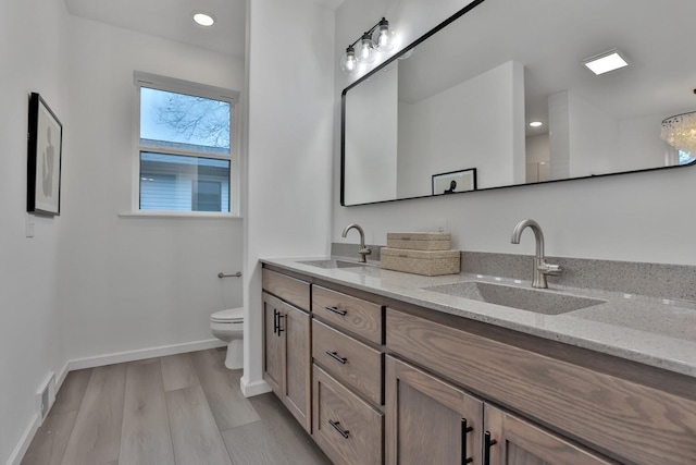 bathroom with wood-type flooring, vanity, and toilet