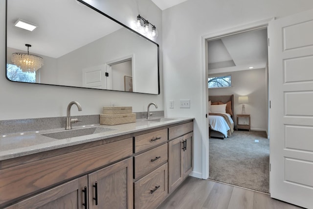 bathroom featuring vanity, wood-type flooring, and a chandelier