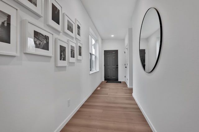 corridor with recessed lighting, light wood finished floors, and baseboards
