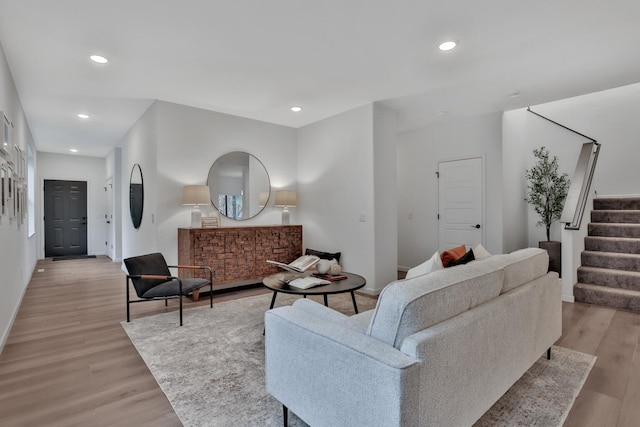 living area with recessed lighting, baseboards, stairs, and light wood-type flooring