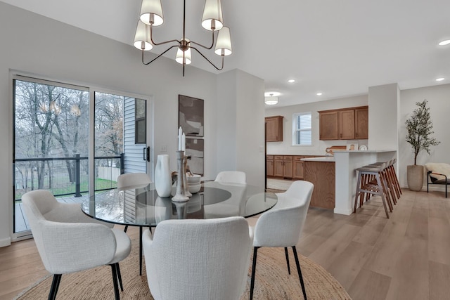dining room featuring recessed lighting, light wood finished floors, and an inviting chandelier