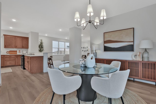 dining area featuring a chandelier, light wood-style flooring, and recessed lighting