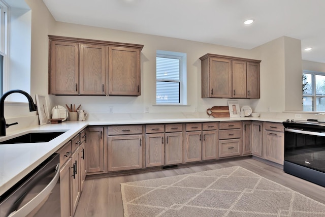 kitchen with a sink, recessed lighting, light wood-style floors, dishwasher, and electric stove