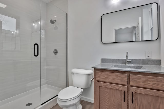 full bath featuring a stall shower, toilet, baseboards, wood finished floors, and vanity
