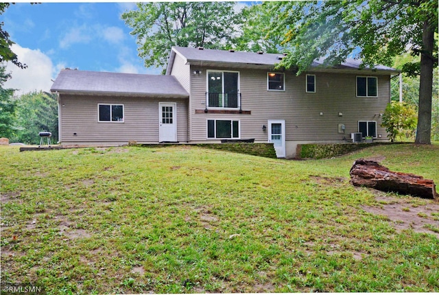 back of property with a yard and central AC unit