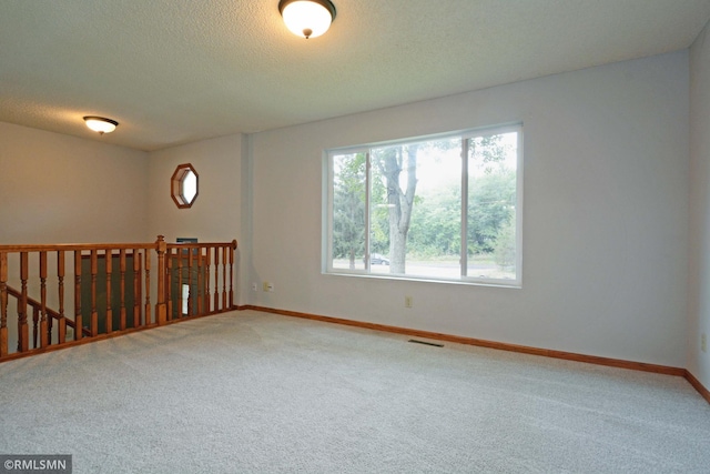 carpeted spare room with a textured ceiling