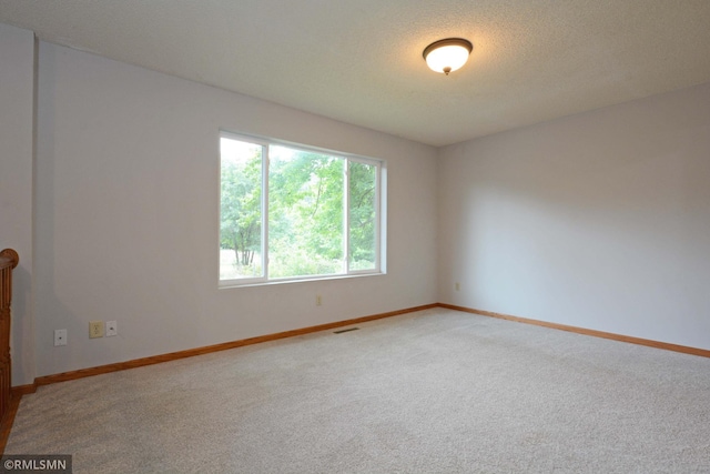 carpeted empty room with a textured ceiling