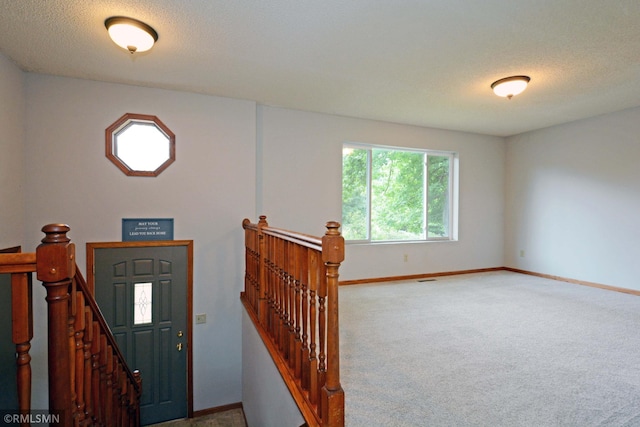 carpeted entrance foyer featuring a textured ceiling